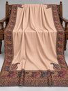 Blush beige Kani shawl with multicolour paisley border displayed open on a studio bench — Taj Mehal Handicrafts