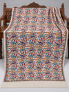 Ivory parrot embroidered shawl with colourful flowers, green vines and a plain edge without tassels, displayed on a wooden bench | Taj Mehal Handicrafts