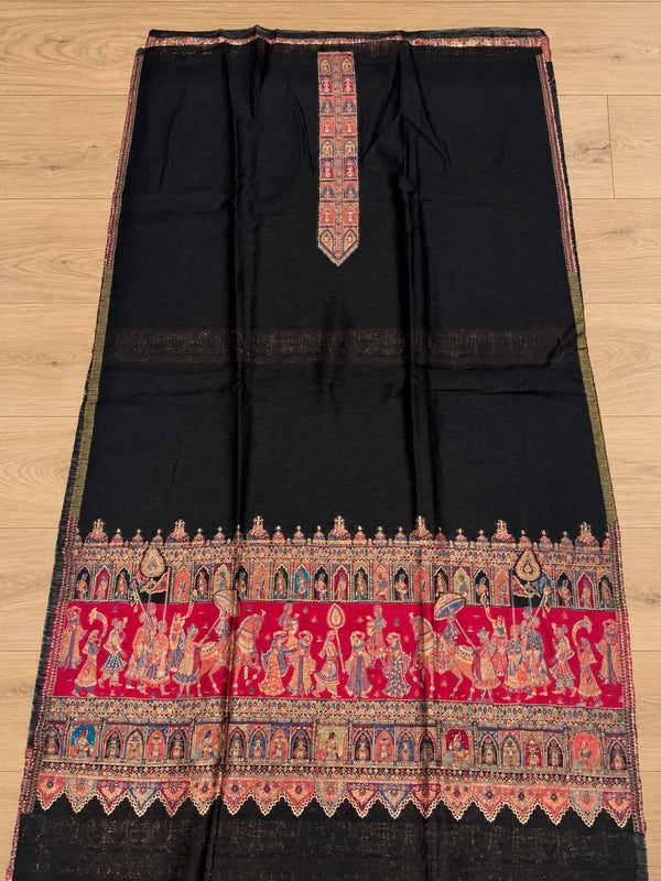 Black Moonlight Shikargah unstitched suit fabric with ornate red and multicolour border, displayed on a wooden floor – Taj Mehal Handicrafts