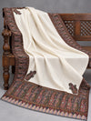 Close view of the ivory Kani shawl's multicolour paisley border and striped edge on a bench — Taj Mehal Handicrafts