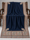 Navy blue Kani shawl with a multicolour paisley border displayed open on a studio bench — Taj Mehal Handicrafts